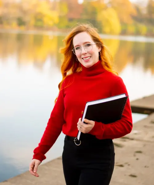 a young woman walking towards the camera smiling